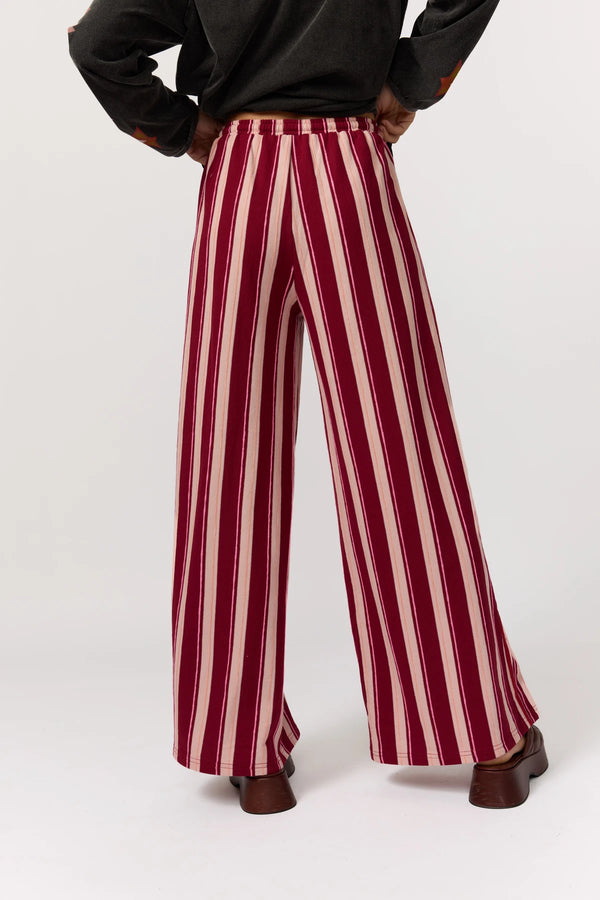 Maroon and white striped pants worn by a person on a white background