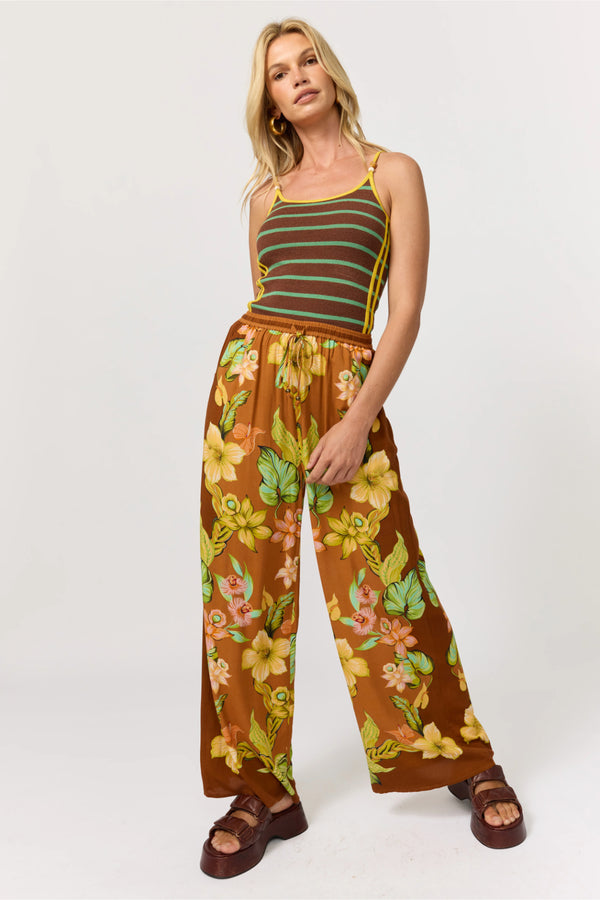 Woman wearing a striped top and floral pants on a white background