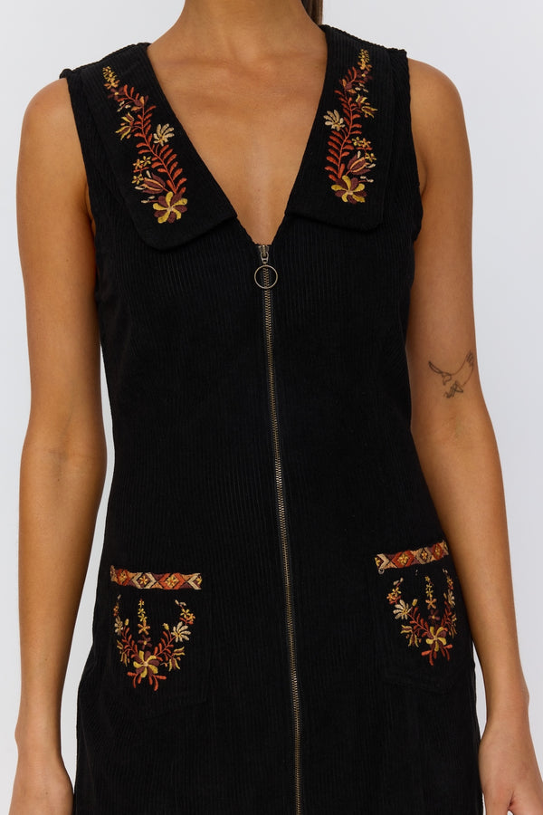 Black sleeveless dress with floral embroidery on a white background