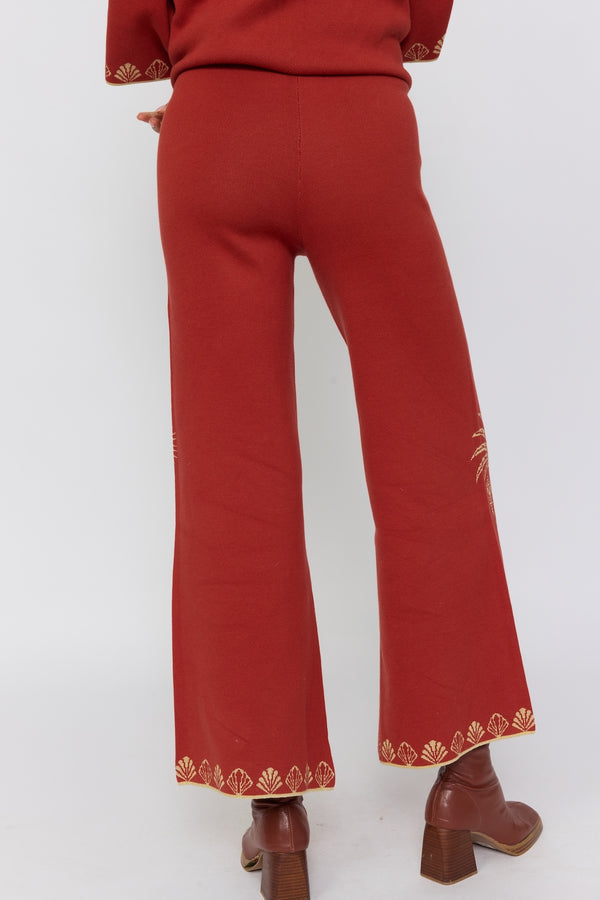 Red pants with gold embroidery on a white background