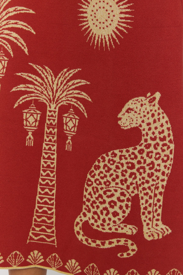 Decorative fabric with a leopard, palm tree, and sun design on a red background