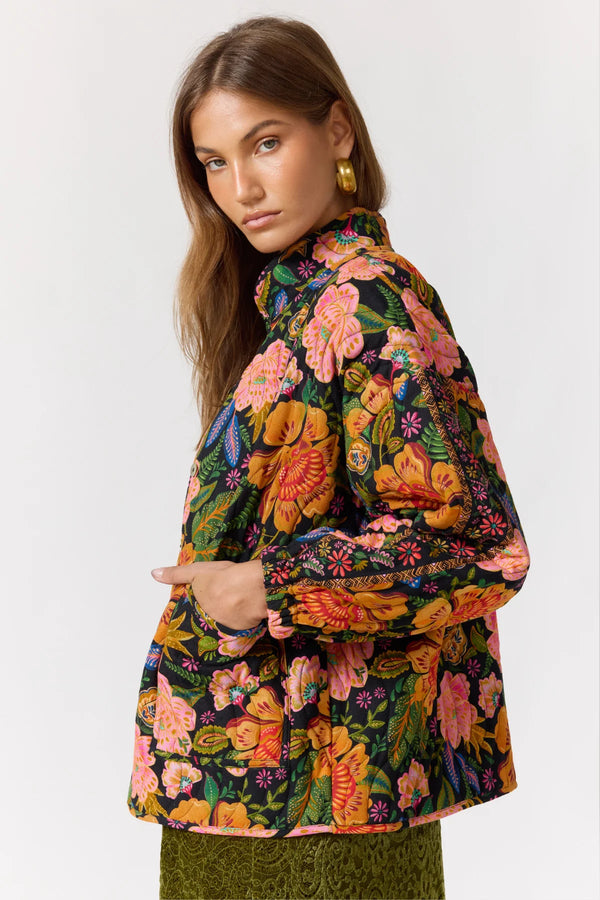 Woman wearing a colorful floral jacket on a white background