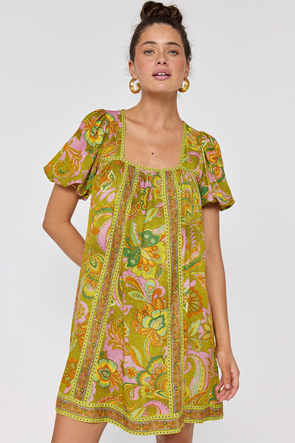 Woman wearing a colorful patterned dress on a white background