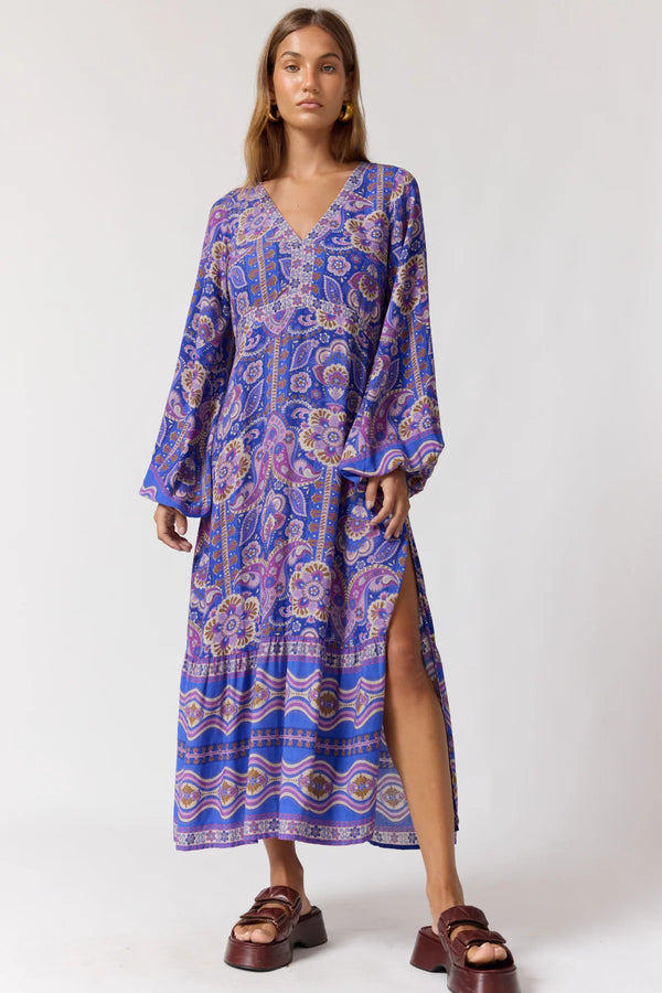 Woman wearing a blue patterned dress on a white background
