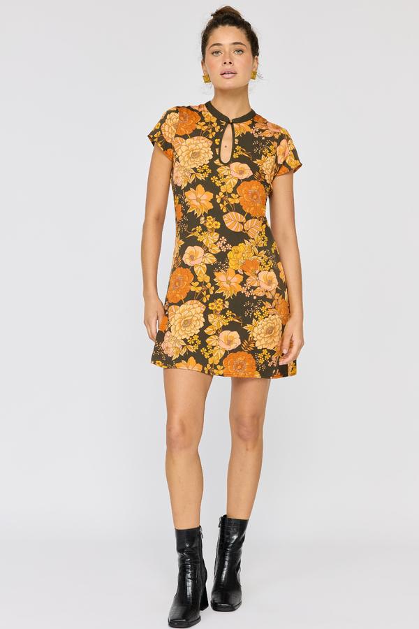 Woman wearing a floral dress with black boots on a white background