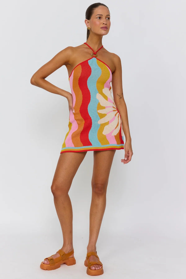 Woman wearing a colorful halter dress on a white background