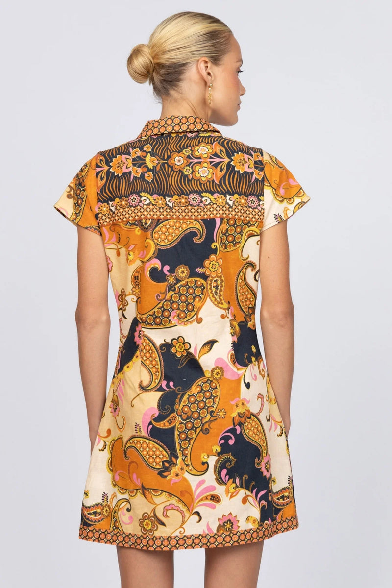 Woman wearing a patterned dress on a plain background