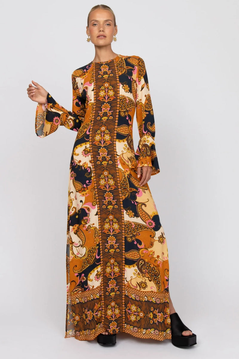 Woman wearing a long, patterned dress on a white background