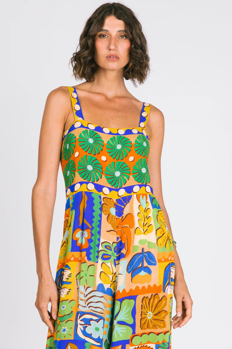 Woman wearing a colorful patterned dress on a plain background