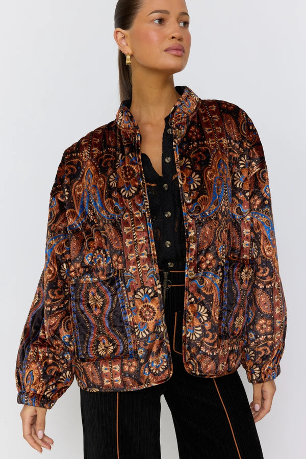 Woman wearing a patterned jacket against a white background