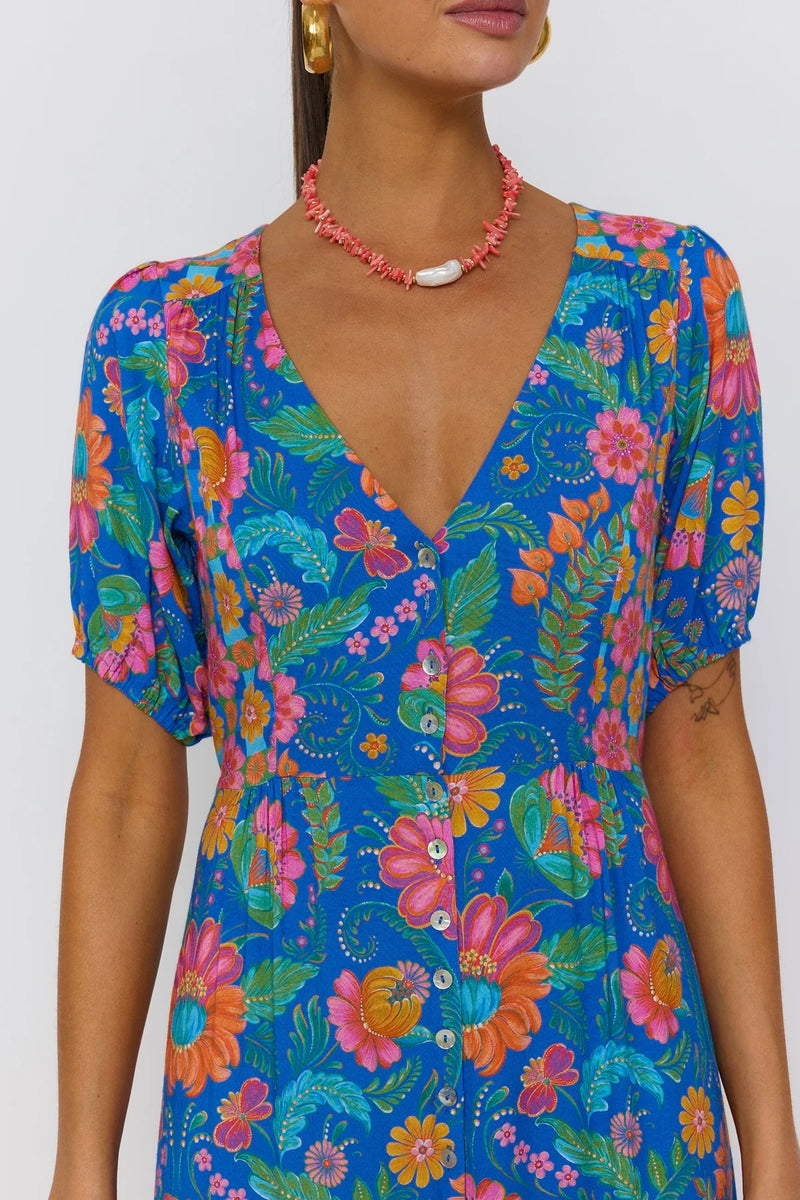 Woman wearing a colorful floral dress with a white background