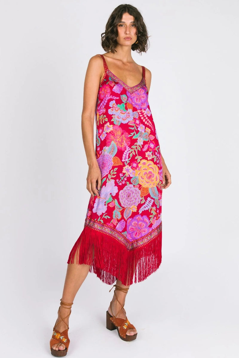 Woman wearing a colorful floral dress with fringes on a white background