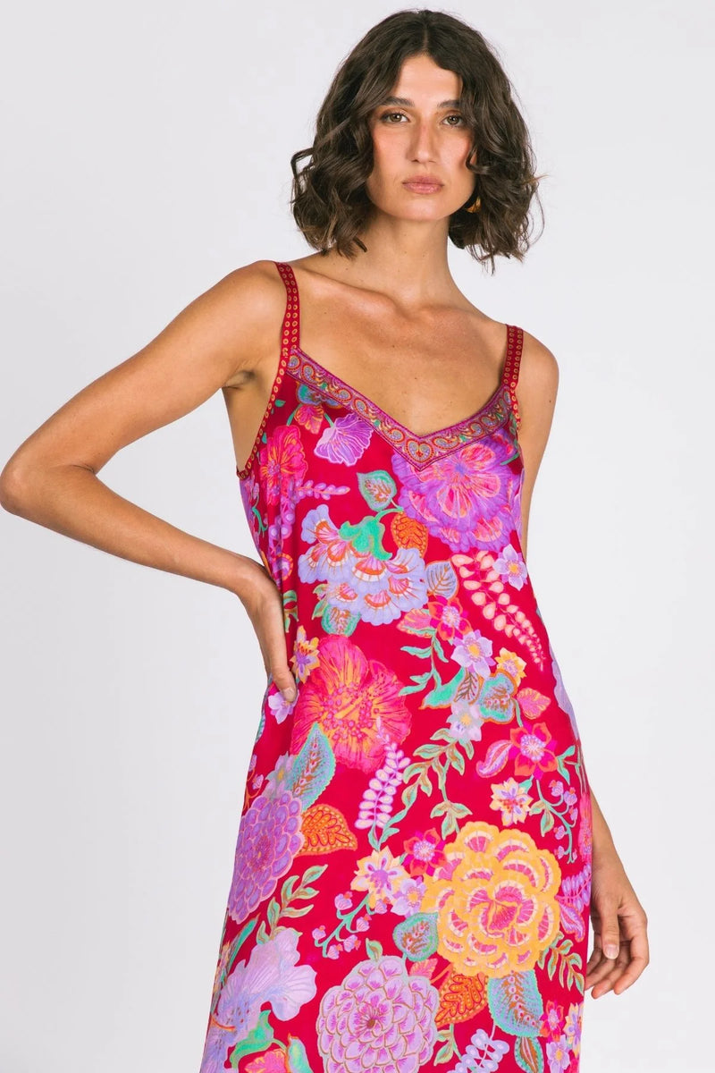Woman wearing a vibrant floral dress on a white background