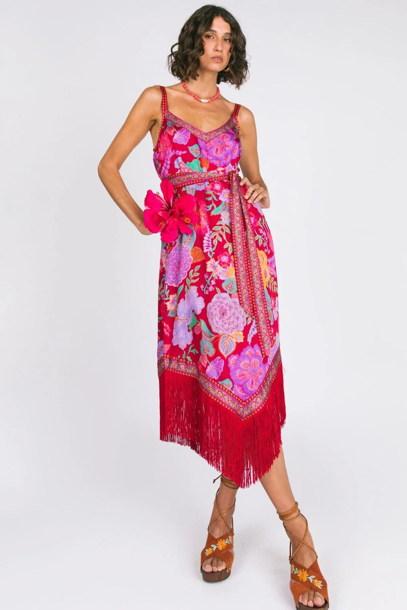 Woman wearing a vibrant floral dress with fringes on a white background