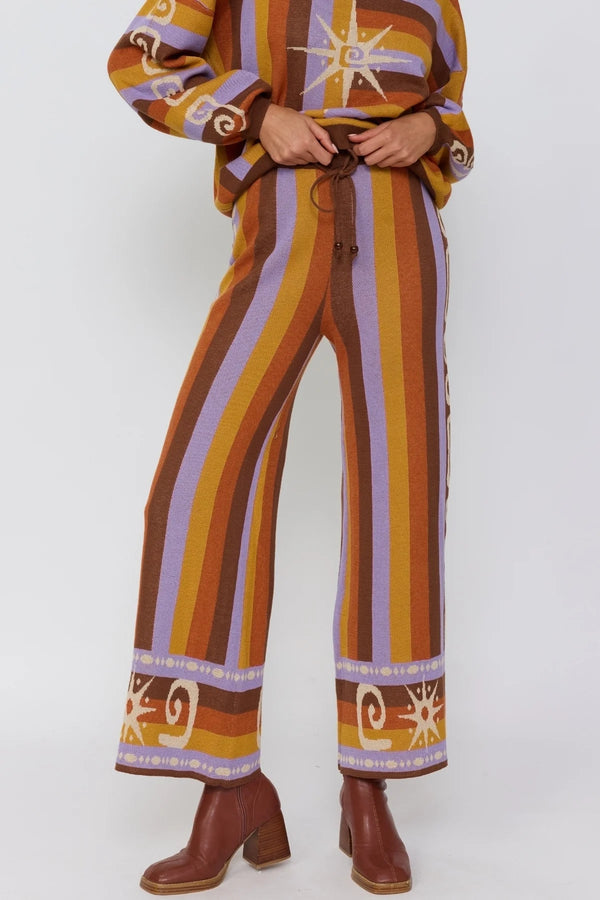 Person wearing a colorful striped outfit with patterns on a white background