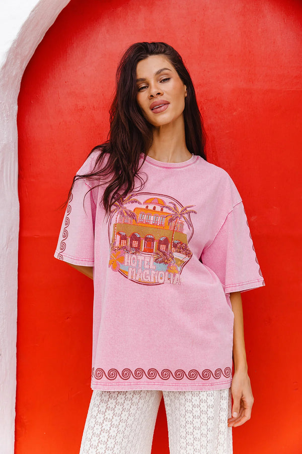 Woman wearing a pink t-shirt with a graphic design against a red background