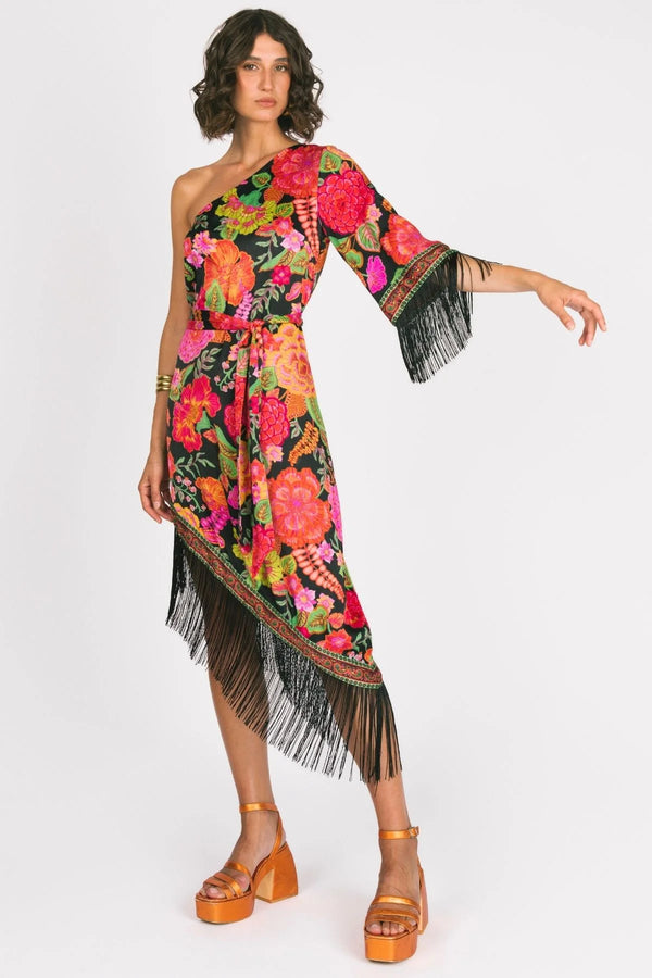 Woman wearing a colorful floral dress with fringe details on a white background