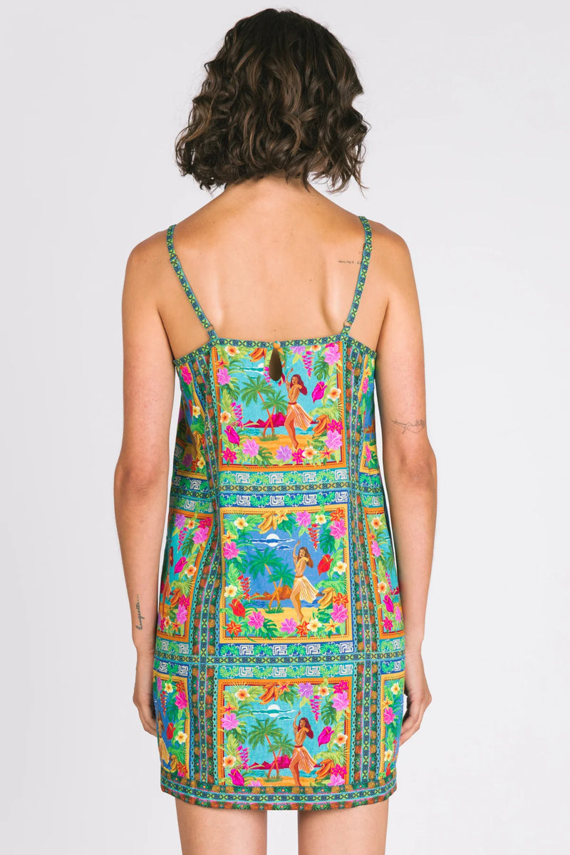 Woman wearing a colorful dress with a pattern on a plain background