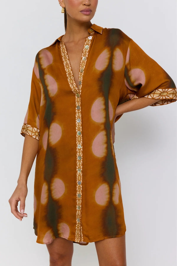 Woman wearing a patterned dress with a plain background