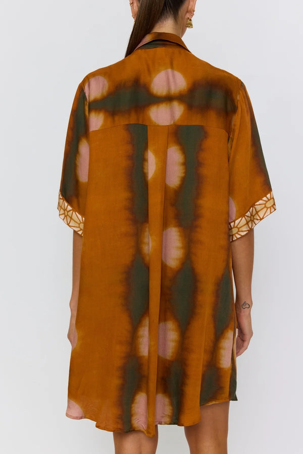 Woman wearing a patterned dress with a white background