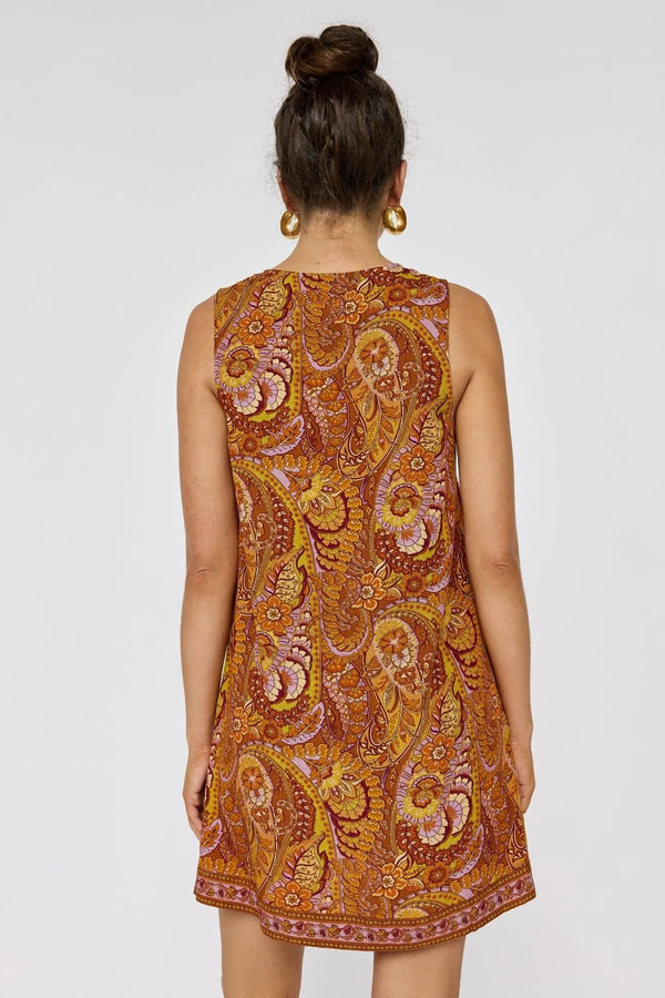 Woman wearing a patterned dress on a plain background