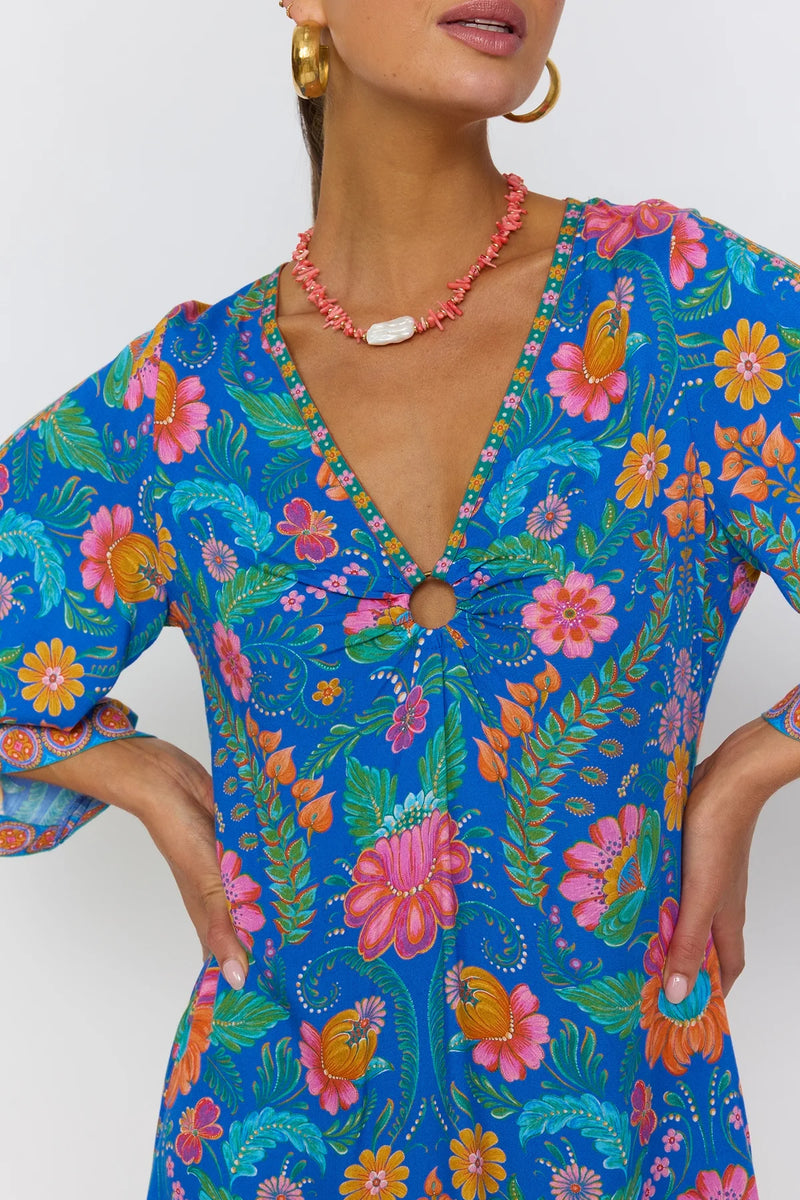 Woman wearing a colorful floral dress with a white background