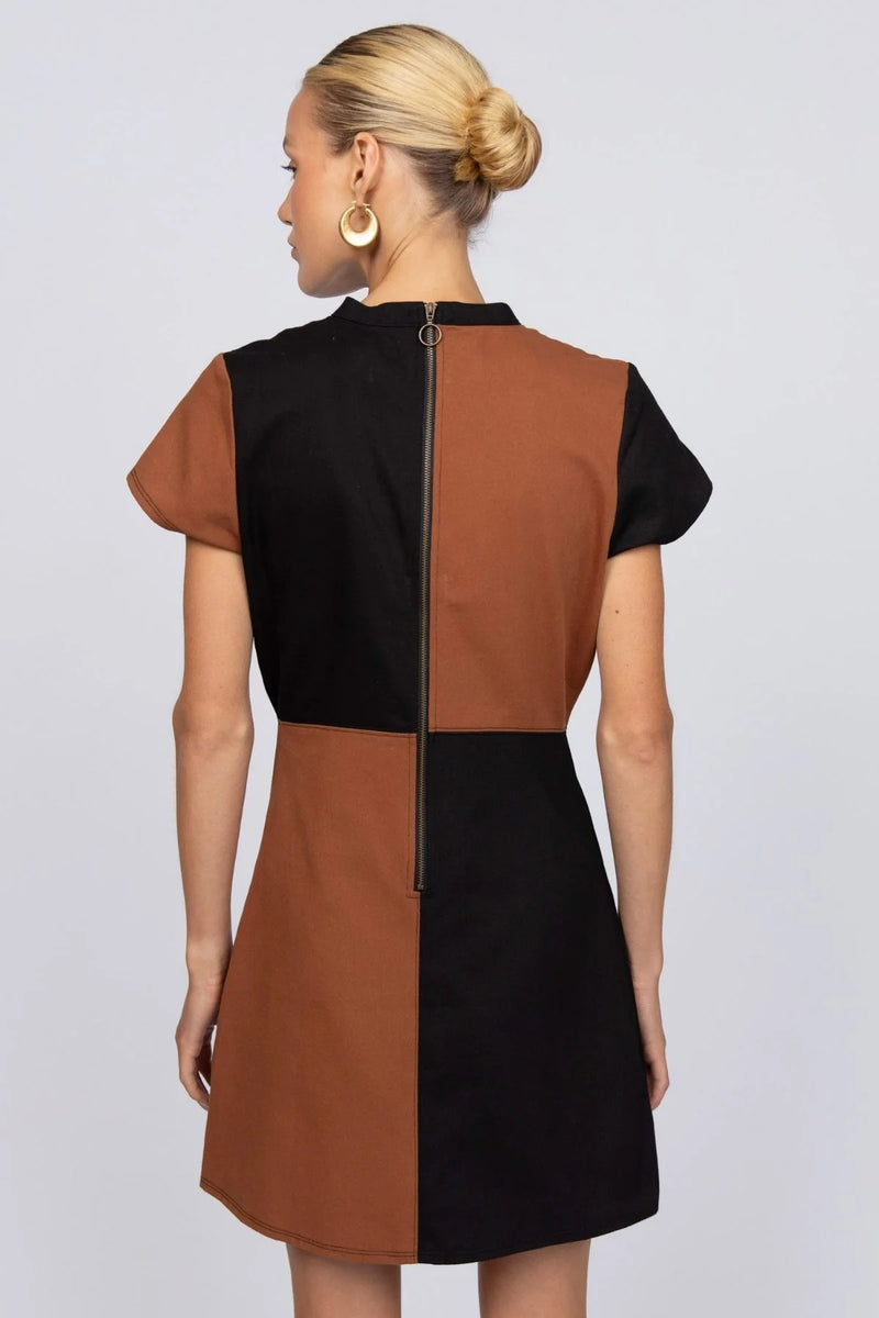 Woman wearing a black and brown dress against a white background