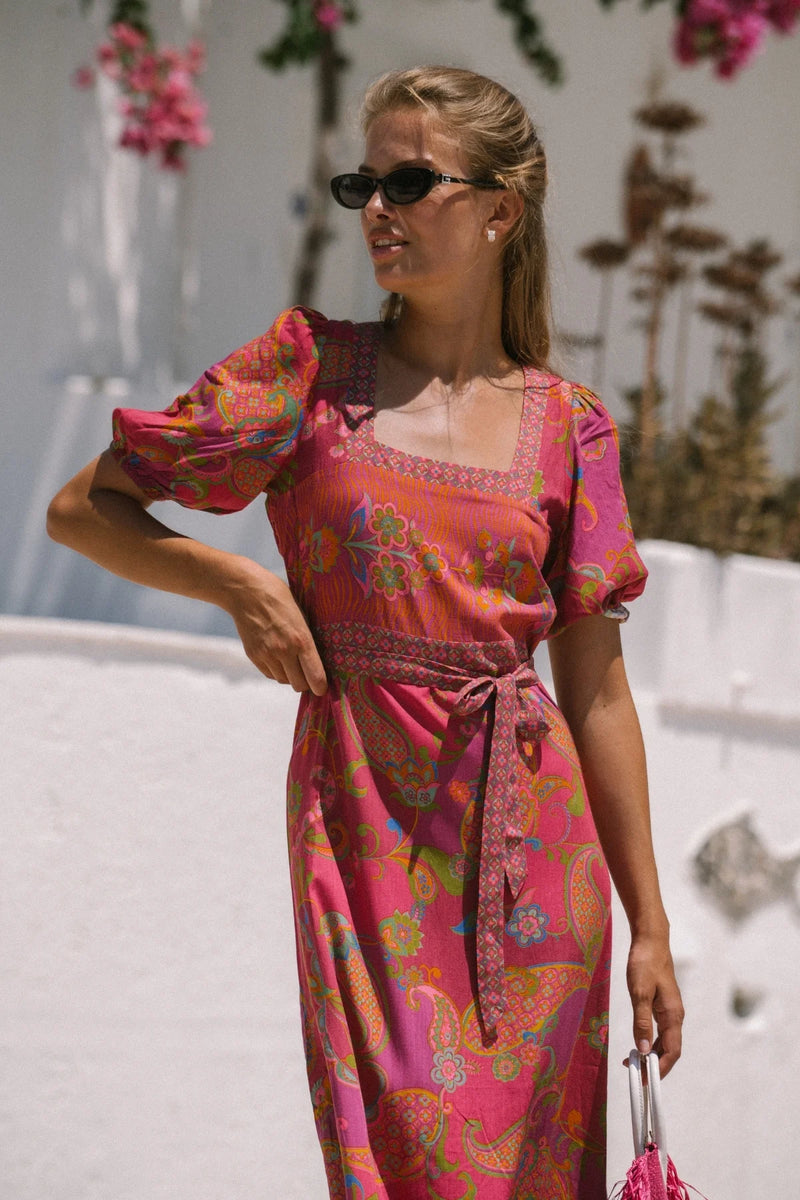 Woman wearing a colorful dress with a blurred outdoor background