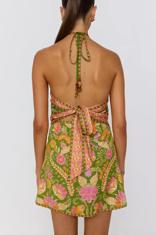 Woman wearing a green floral dress with a white background