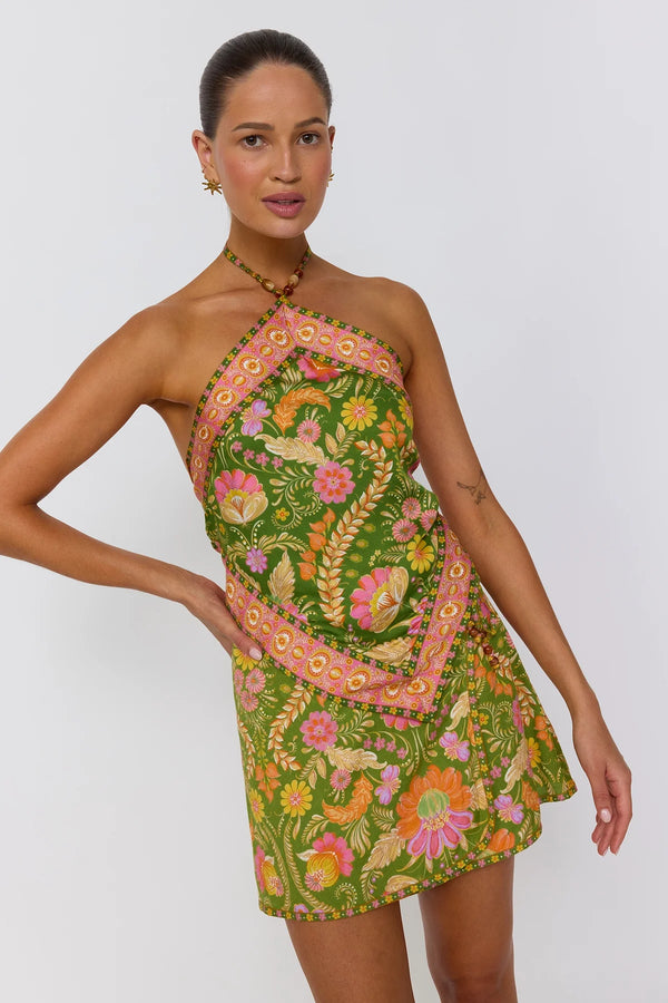 Woman wearing a green floral dress against a white background