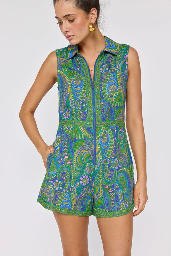 Woman wearing a green and blue patterned romper on a white background