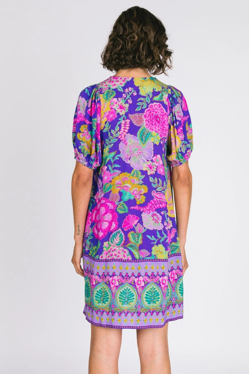 Woman wearing a colorful floral dress on a white background