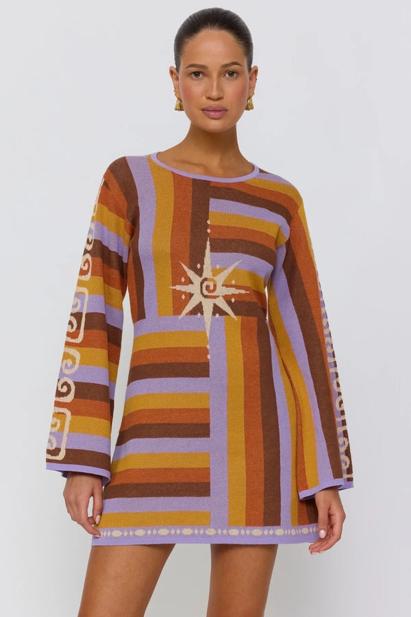 Woman wearing a colorful patterned dress on a white background