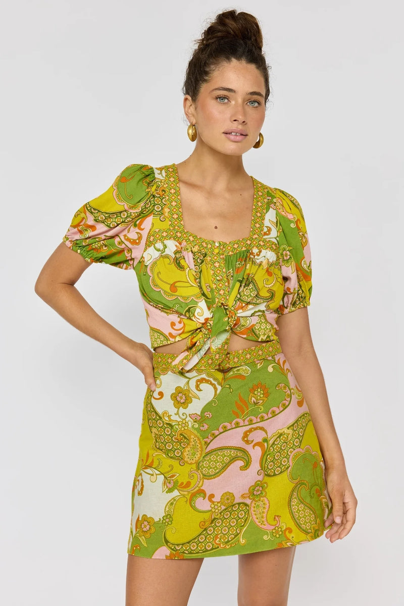 Woman wearing a colorful patterned dress on a white background