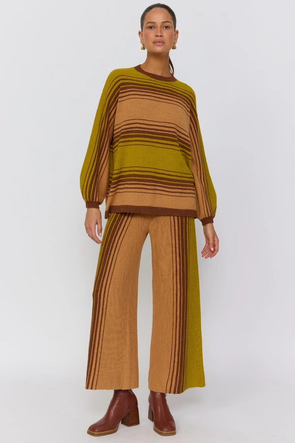 Woman wearing a brown and green striped outfit on a white background