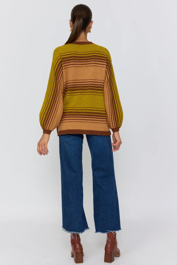 Person wearing a striped sweater and blue jeans on a white background