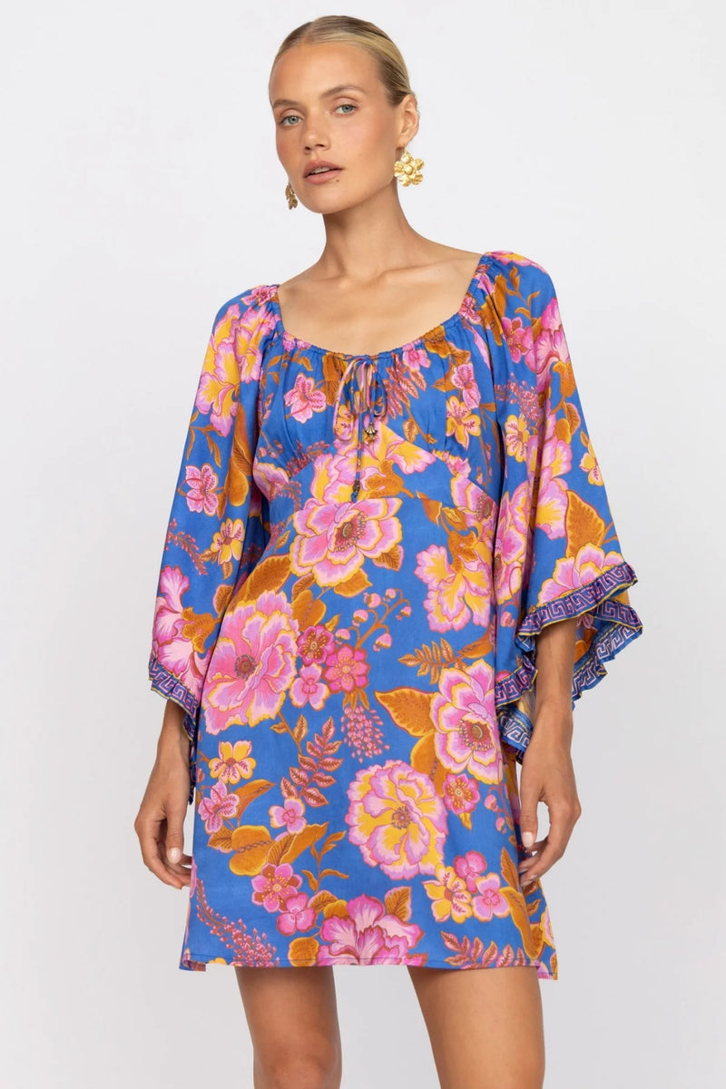 Woman wearing a colorful floral dress on a white background