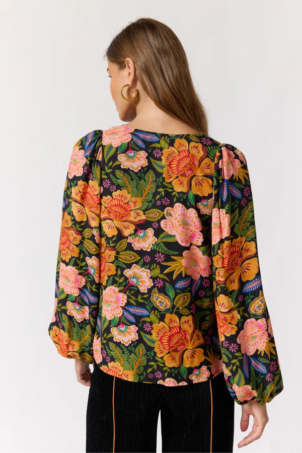 Woman wearing a colorful floral blouse on a white background