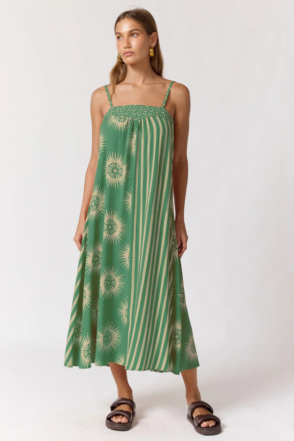 Woman wearing a green and white patterned dress on a white background