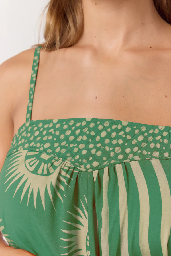 Green and beige patterned top worn by a woman.