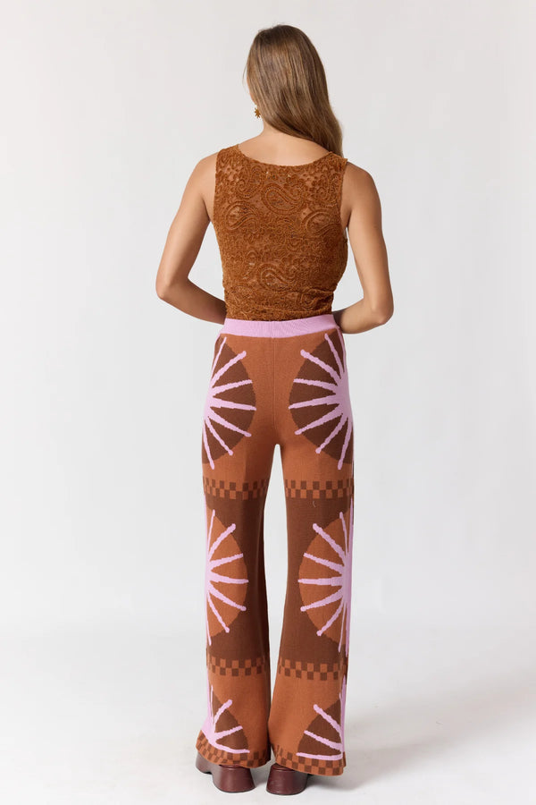 Woman wearing a brown and pink patterned outfit on a white background