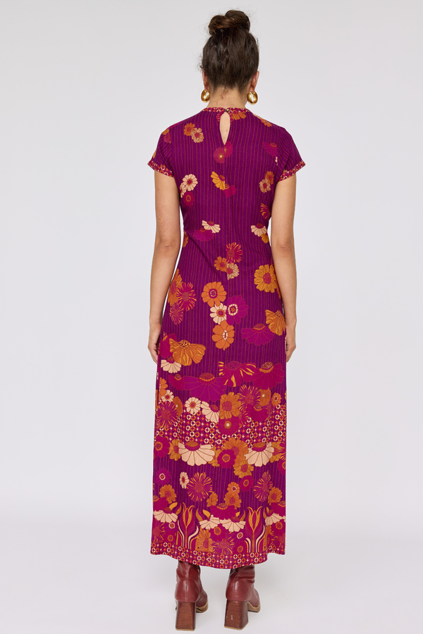 Woman wearing a purple floral dress on a white background